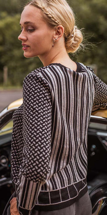 eine Frau in einem schwarz-hellgrauen Pullover mit verschiedenen Mustern von Alma & Lovis